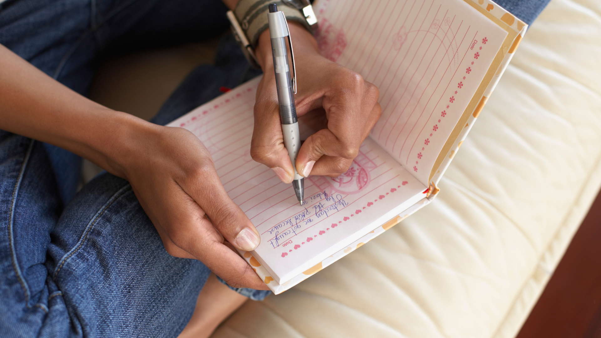 An image showing a woman writing in a journal.